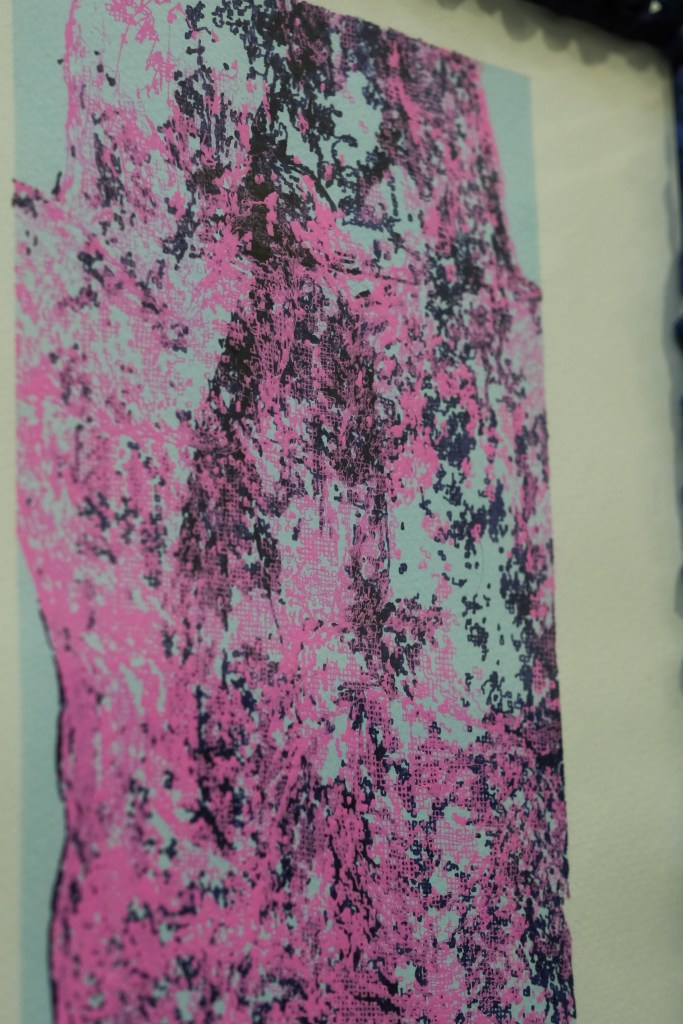 Abstract artwork featuring a textured design in shades of pink, black, and blue.