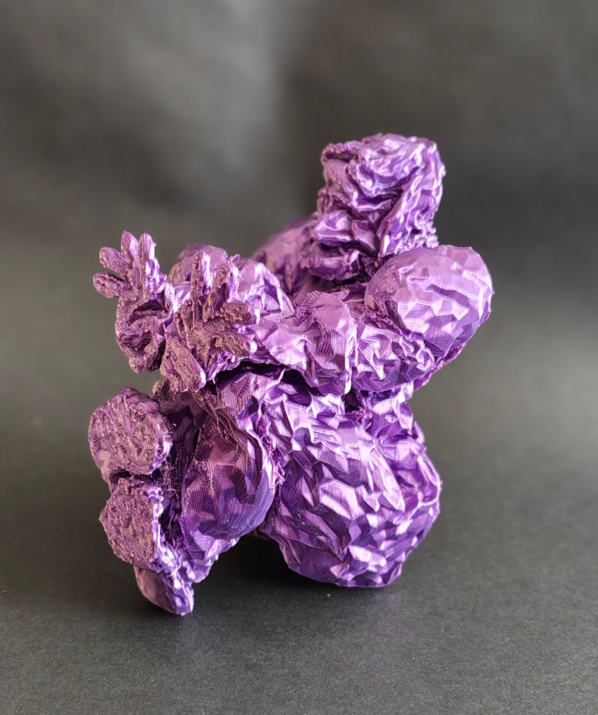 A crumpled purple sculpture resembling an abstract figure, set against a dark background.