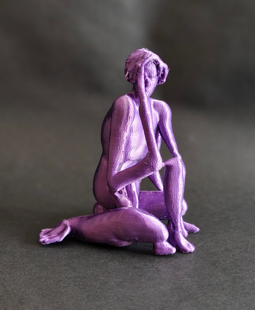 A purple 3D printed sculpture depicting a seated figure with their hand on their face, accompanied by a small dog at their feet.